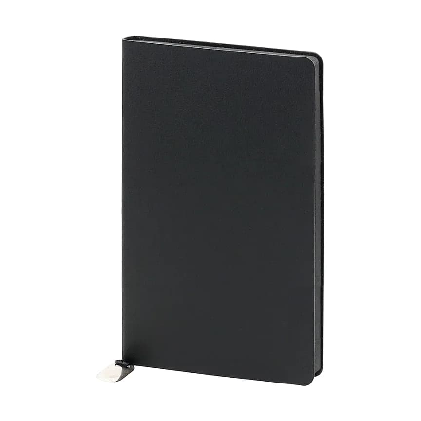 Siyah kapaklı defter; desensiz mat yüzey, sağ kenarda sayfa kalınlığı ve altta siyah kurdele.
