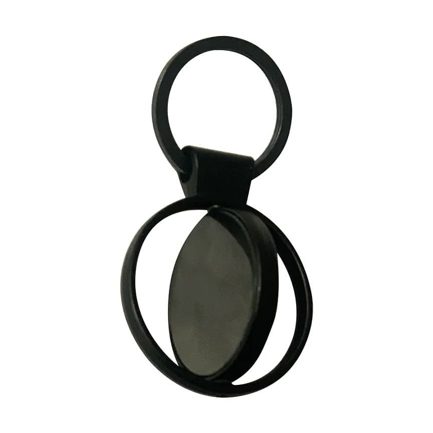 Siyah metal gövdeli, menteşeli üst halkası ve oval plakayı çevreleyen döner çerçeveli anahtarlık.